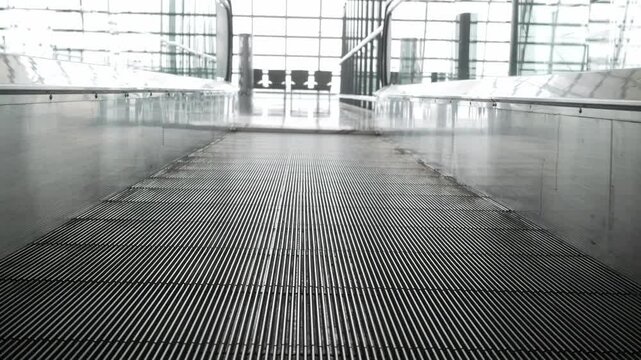 low angle view on moving escalator in the airport while moving operating in modern airport terminal leads to departure gate.Electric escalator in metro airport terminal