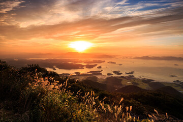 Sunrise view of silver grass on Geumosan Mountain with the background of Hallyeohaesang National Park in autumn at Hadong-gun, South Korea 