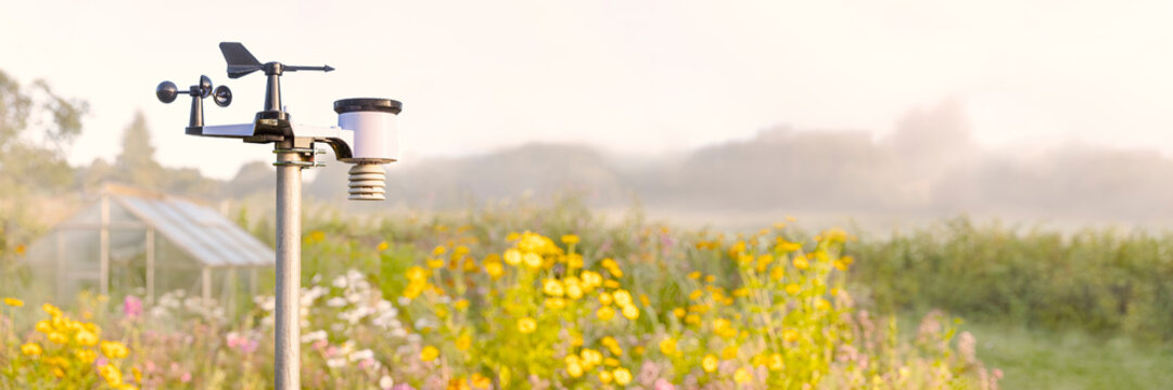 Private Wetterstation in einem Garten mit Gew&auml;chshaus bei Sonnenaufgang