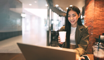 Happy business freelance asian woman holding coffee cup at cafe urban lifestyle