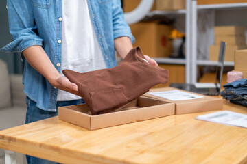 Young Asian man, distributor, online shop owner, small business owner, standing in warehouse and preparing to ship goods, with parcel boxes.