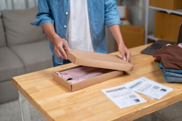 Young Asian man, distributor, online shop owner, small business owner, standing in warehouse and preparing to ship goods, with parcel boxes.