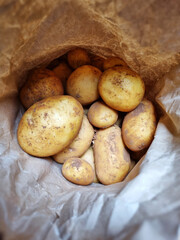 Unwashed new potatoes in a paper bag