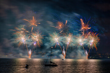 View of colorful fireworks display over Lake Zurich with festive reflections, Zurich, Switzerland.