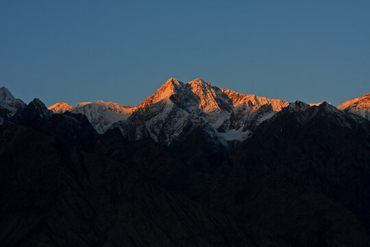 View of majestic snow-capped mountains at sunset with the Indus River, Skardu, Pakistan.