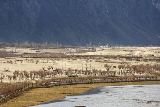 View of breathtaking mountain and tranquil valley with a serene river and trees, Skardu, Pakistan.