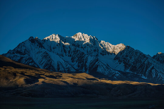 View of majestic snow-capped mountains under a clear sky at sunset, Shandur Pass, Gilgit-Baltistan, Pakistan.