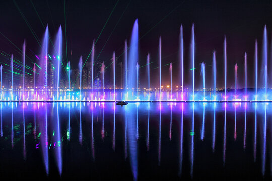 View of colorful illuminated fountain with vibrant lights and reflections, Dubai, United Arab Emirates.