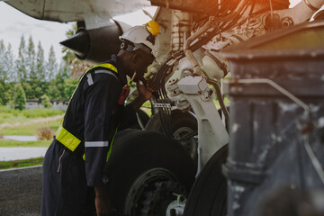 Mechanics inspect the engines of a large plane before takeoff at a summer airport.