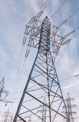 High-voltage power lines and pylons against the blue sky