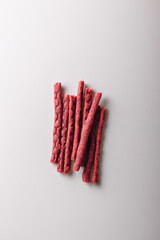 Dry salmon sticks heap, jerky fish meat pile on white background. Copy space, top view. Advertising banner, template. Product presentation. Vertical shot