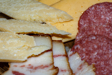 Sliced ​​cheese, sausage and lard on a plate.