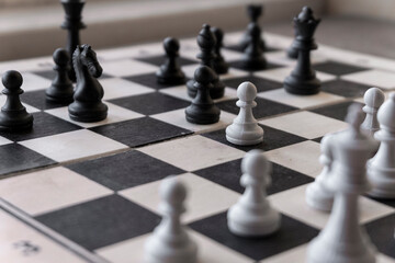 Black and white chess pieces on a chessboard. Close-up.