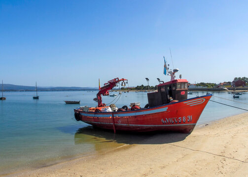 Mussel farm collection boat stranded on a beach. Illa de Arousa, Galicia, Spain.