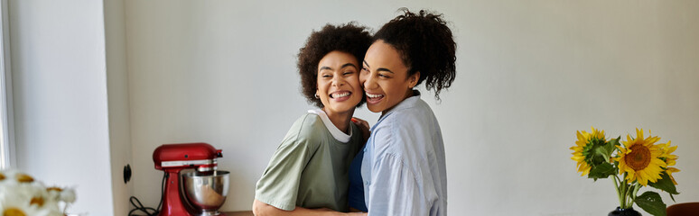 Two women embrace happily while sharing a cozy moment at home.