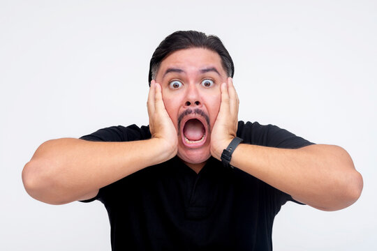 A stunned middle aged man with mouth agape, eyes wide open, and both hands squishing his face. A mind-blowing experience. Isolated on a white background.