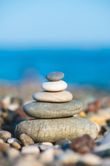 A pyramid of stones on a pebble beach by the sea, the concept of balance, balance, tranquility, relaxation