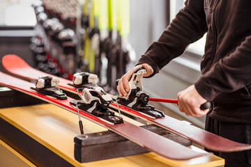 Ski Equipment adjusting by Ski Master. Ski Service and Ski Rental Concept. 
