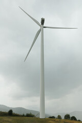 Fototapeta premium windmill farm, green electricity production, electricity production, rainy weather windmill, clean energy, renewable energy background,