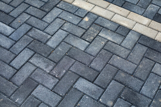 Gray interlocking paving stones, top view. Brick stone street road or sidewalk, pavement texture