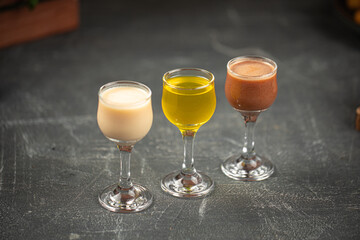 Glasses of assorted liquor on grey table