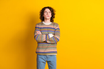Portrait of minded guy with wavy hairdo dressed ornament sweater arms crossed look empty space...