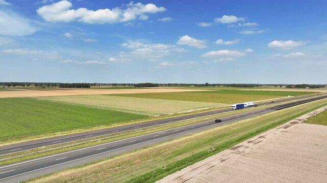 Traffic driving on the A6 highway in the Noordoostpolder Flevoland during a warm summer day.