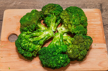 A chef cuts fresh broccoli on a cutting board