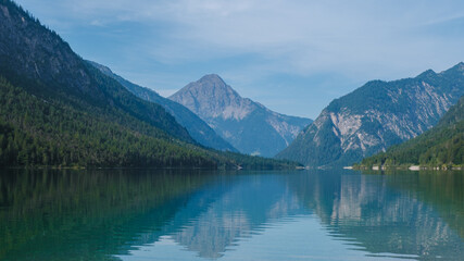 Tranquil reflection over the pristine waters of Plansee in the heart of the Austrian Alps