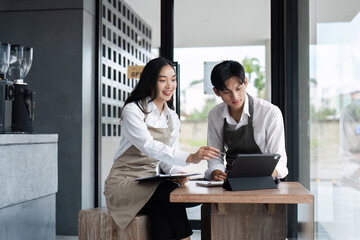 Young Entrepreneurs Discussing Business Strategy in Modern Cafe Setting with Digital Tablet