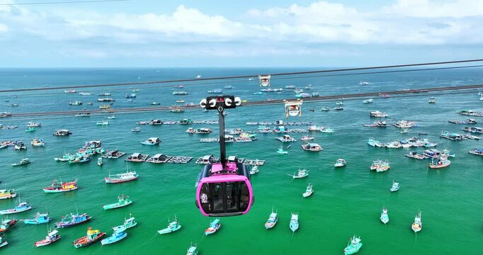 Aerial drone shot of cable car in Phu Quoc island, Vietnam. Sunset, harbour, floating boats and ships, sea waves, ocean waves.