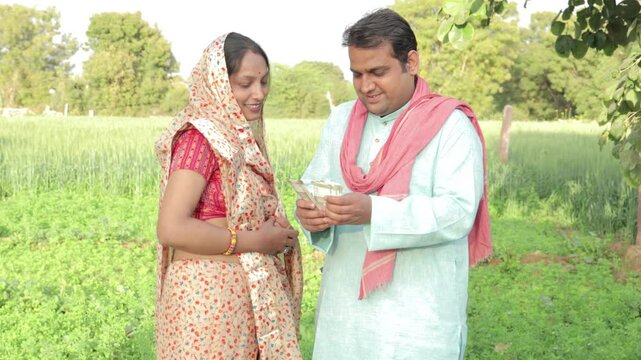 Happy Indian farmer couple counting rupees note at agriculture field, Rural india.  Profit and Prosperity, Finance and Economy,  4k