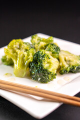 Broccoli on a white plate on a black background.food concept.diet.