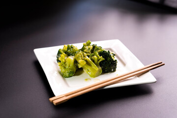 Broccoli on a white plate on a black background.food concept.diet.