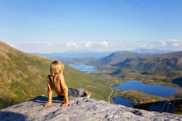 Children and adults, family with dog, hiking Grytetippen trail in Senja, Lofoten on a sunny hot summer day