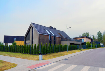 BarnHouse in village. Modern luxury house in suburb. Street with Scandi home. Modern Scandinavian Barnhouse. Contemporary barnhouse. Rows of Houses along road village. Fence house at street in suburb.