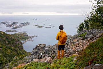 Fototapeta premium Children and adults, happy family with dog, climbing Festvagtinden via Heiavatnet trail in Norway