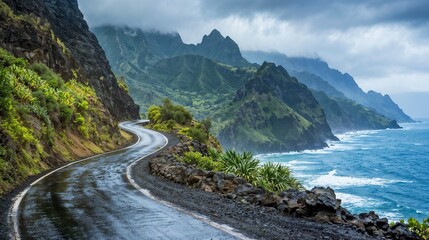 A winding road to the ocean with mountains in the background