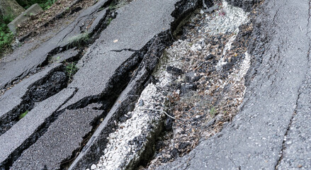 Cracks on an asphalt road close-up, destruction as a result of a mudflow