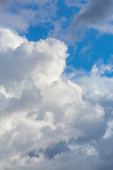 Obraz premium Fluffy white clouds on a bright blue sky background, serene natural sky scene, weather and nature concept.