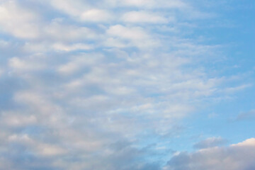 Morning sky. Beautiful fluffy clouds painted in pastel painterly colors at sunrise. Multicolor background or wallpaper