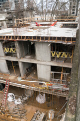 Concrete Building Under Construction with Reinforcement Bars and Scaffolding.