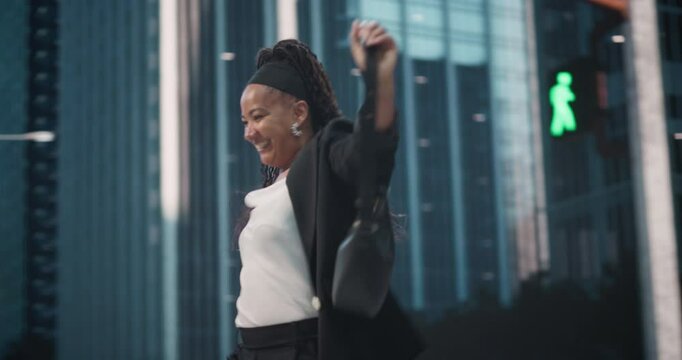 Portrait of an African Female Performing a Celebratory Dance in an Urban City Center while Diverse People Commute to Work. Cheerful Black Woman Dancing and Fooling Around on a Busy Street