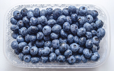 Box with fresh blueberries isolated on white. Top view. Concept of healthy eating. Weight loss.