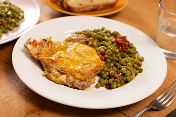 Fried crispy boneless skinless chicken with green peas on a plate in a restaurant