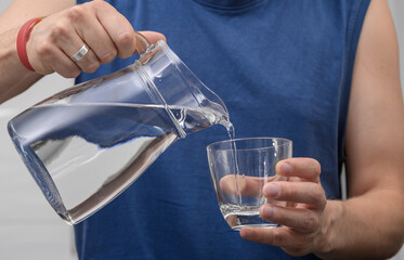A young man replenishes his fluids on hot days with fresh tap water.