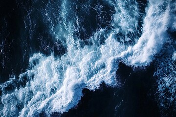 Dark blue ocean waves are creating white sea foam as they crash. This image would be perfect for a nature lover or someone looking for a calming background
