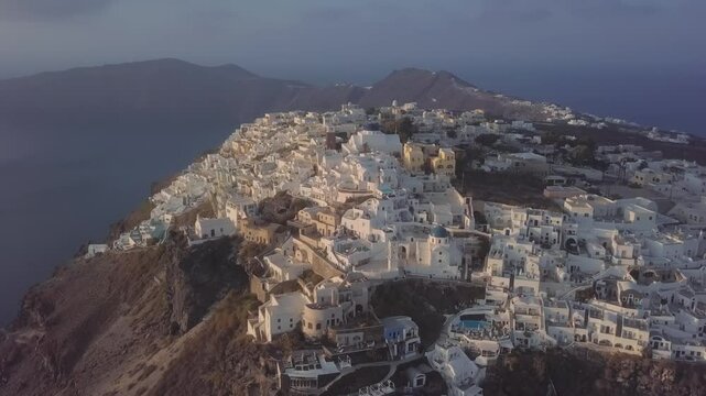 Flight over of traditional terraced white villas in Imerovigli village near Fira at sunset, Santorini, Greece. 2.5x speeded up from 24 fps.