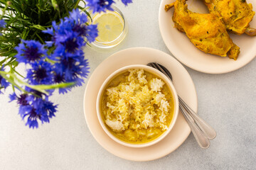 Stewed rabbit with rice, broccoli and rice cakes, a served table with food and a vase of flowers, a delicious hearty lunch or dinner