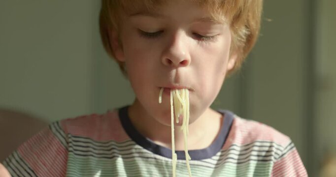 Cute Kid Boy Eat Spaghetti with Cucumber Vegetarian Food For Breakfast or Dinner. Slow motion 60 fps 4K 10-bit